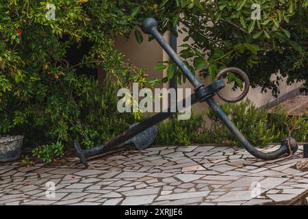 An old metal anchor from a ship near the house Vrbnik Croatia 27.06.2024 Stock Photo