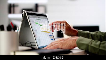 Project Management Software And Business Plan Schedule In Office Stock Photo
