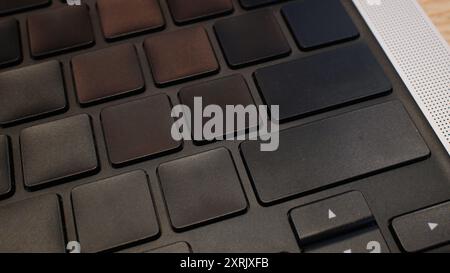 Closeup of a sleek, modern laptop keyboard with dark keys in low light. Perfect for tech, business, or productivity concepts Stock Photo