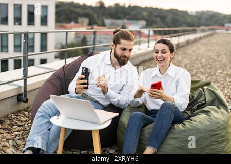 Young professionals working on rooftop with digital devices Stock Photo