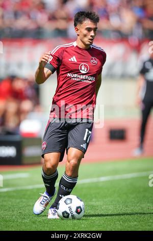 10 August 2024, Bavaria, Nuremberg: Soccer: Bundesliga 2, 1. FC Nuremberg - FC Schalke 04, Matchday 2 at the Max Morlock Stadium. Jens Castrop from Nuremberg plays the ball. Photo: Daniel Karmann/dpa - IMPORTANT NOTE: In accordance with the regulations of the DFL German Football League and the DFB German Football Association, it is prohibited to utilize or have utilized photographs taken in the stadium and/or of the match in the form of sequential images and/or video-like photo series. Stock Photo