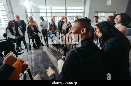 A group of happy and attentive individuals participating in an engaging conference session, showing enthusiasm and connection in a modern setting. Stock Photo