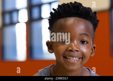Smiling boy in school classroom, looking at camera with joy and excitement Stock Photo