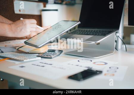 Hand holding a graphics tablet. Market analysis. Notes after the meeting. Home office interior. Stock Photo