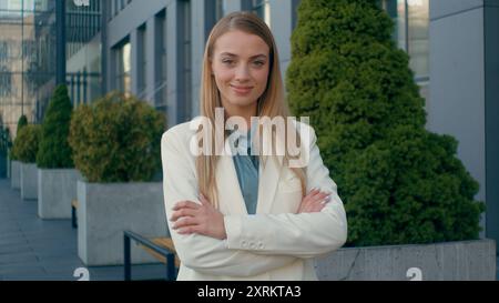Confident smiling Caucasian woman blonde businesswoman employee student in formal suit looking at camera outdoors city downtown. Happy female hr Stock Photo
