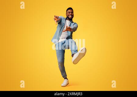 Funny black man dancing and extending his hands to camera Stock Photo