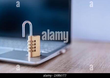 Close-up of an open number padlock on top of a laptop, concept of insecurity, alert, virus, spyware Stock Photo