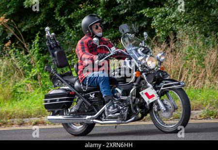 Potterspury,Northants,UK - Aug 11th 2024: Man riding a 2003 Honda VT 125 Shadow motorcycle travelling on a British road Stock Photo