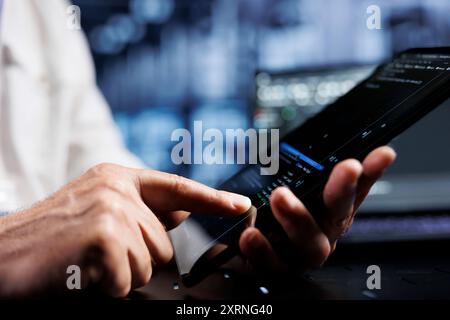 System administrator coding in data center using javascript language, close up. Competent manager updating software on server rigs on tablet terminal, ensuring optimal performance and security Stock Photo