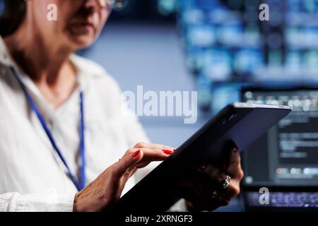 Close up shot of senescent admin writing script code in data center on laptop terminal. Efficient worker doing maintenance work in server room, updating clusters software to prevent malfunctions Stock Photo