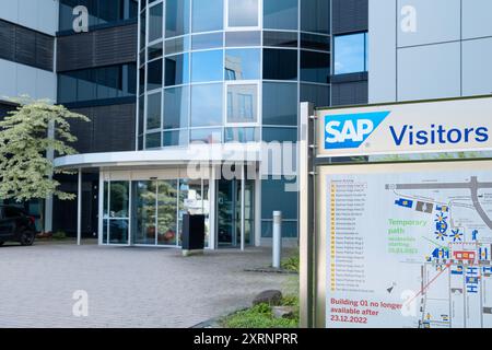 SAP SE logo prominently displayed on modern corporate headquarters facade, SAP corporate campus, symbolizing global software industry leadership, Wall Stock Photo
