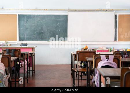 Empty classroom with whiteboard. Empty Modern Classroom With White Interactive Board. Desks and chairs arranged in classroom at high school Stock Photo