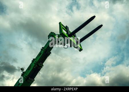 Forklift forks, industrial machinery and equipment against dramatic sky, low angle view Stock Photo