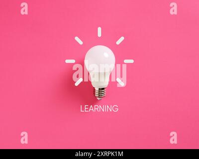 White light bulb on a pink background with hand drawn lines around, symbolizing learning, idea and creativity. Education concept. Stock Photo