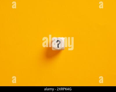 Problem, query, solution, confusion or counseling concepts. Single wooden cube on a yellow background with a question mark symbol. Stock Photo