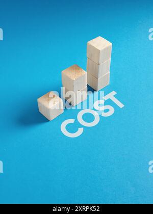 Concept of cost increase illustrated by wooden blocks forming an ascending chart on blue background. Stock Photo
