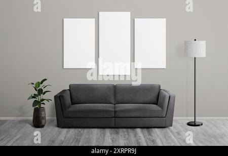 Three art canvases on living room wall mockup with plant, sofa, and lamp on the floor. Perfect art presentation template for showcasing design and hom Stock Photo
