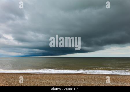 Vivid Coastal Scene with Dramatic Cloud Patterns Over the Ocean at Aldeburgh beach, Suffolk, England Stock Photo