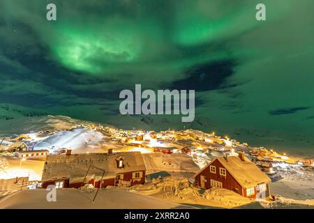 Green northern lights, aurora borealis over a typical greenlandic red house, Tasiilaq, East Greenland, Greenland Stock Photo