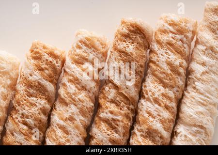 Crispy and delicious coconut crispy egg roll snack close up on white background Stock Photo