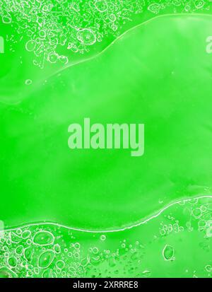 Abstract close-up of bright green liquid with floating bubbles, creating a vibrant, textured effect. Template for backgrounds, science themes, or crea Stock Photo