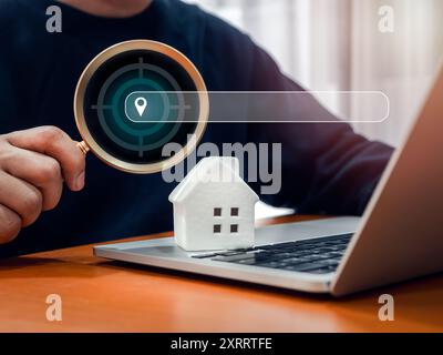 Online searching property, house value, home buy and sell, real estate investment concept. Location map pointer icon in magnifying glass in man hand w Stock Photo