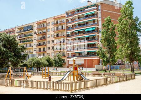 Barcelona Spain,Catalonia Catalunya,Carrer de Nicaragua,Sants-Montjuic,Jardins de Malaga,playground fenced,children playing,multi-story apartment buil Stock Photo