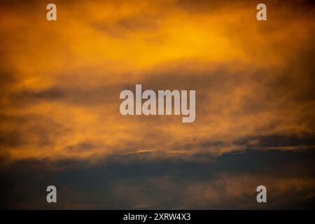 The setting sun creates an abstract pastel painting of sky and clouds. Stock Photo