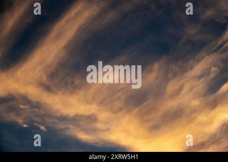 The setting sun creates an abstract pastel painting of sky and clouds. Stock Photo