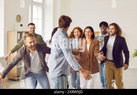 Group of a happy smiling business people having fun greeting coworker in office. Stock Photo