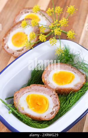 Freshly cooked home made Scotch Eggs with a light green salad. Stock Photo