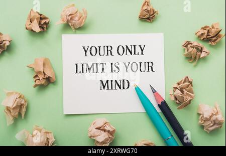 A piece of paper with the words Your only limit is your mind written on it. Two pens are placed on the paper, one on the left and one on the right Stock Photo