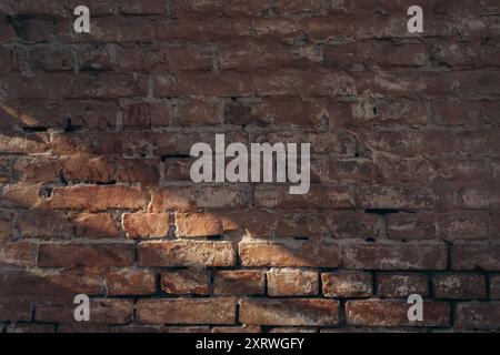 A brick wall with a shadow on it. The wall is old and has a rough texture. The shadow is cast on the wall, creating a sense of depth and dimension. Sc Stock Photo