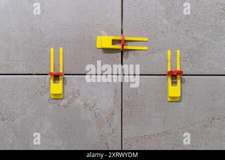 Tile installation using plastic leveling clips and wedges. Ensuring a smooth Stock Photo