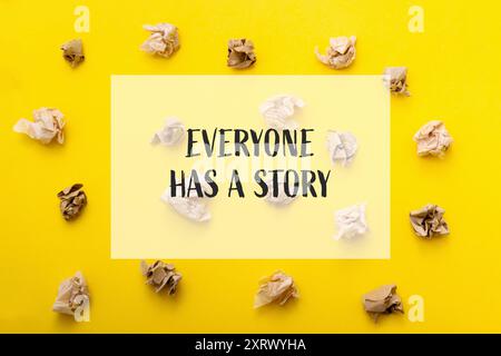 A yellow background with a bunch of crumpled paper on it. The words Everyone has a story are written in white on the background Stock Photo