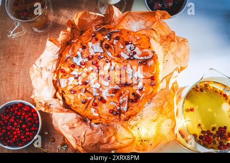 Apple pie Invisible decorated with lingonberries according to a traditional French recipe in baking paper. Selected focus. High quality photo Stock Photo