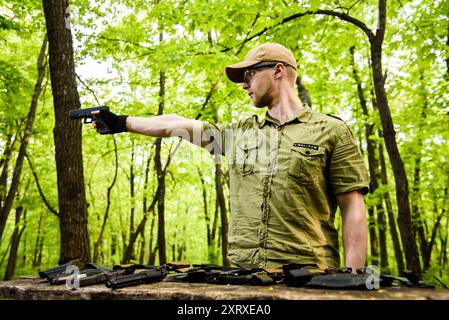 the guy in the woods is cleaning his weapon Stock Photo