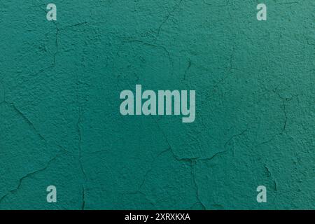 Cracked green paint on the wall. Old peeling painted textured background. Stock Photo