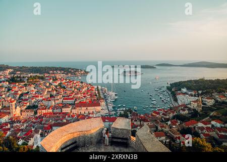 An aerial view of Hvar town and harbor with boats, surrounded by the Adriatic Sea during sunset in Croatia Stock Photo