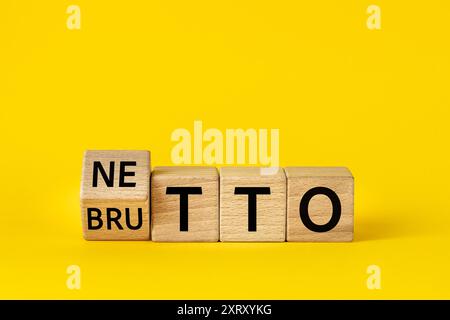 Netto and brutto. Net and gross symbol. Words on wooden blocks change net to gross. Financial concept, Beautiful yellow background, copy space Stock Photo