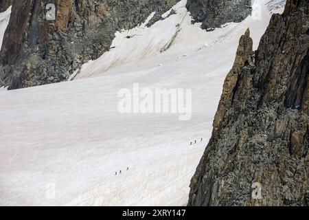 view towards dent du geant at mont blanc with some hikers in snow Stock Photo