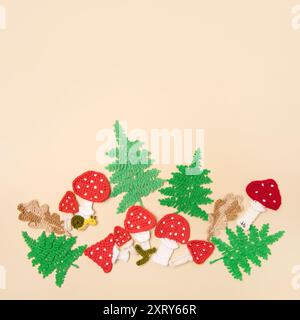 Bright autumn pattern of knitted toys in form leaves of oak, fern and mushrooms with place for text in center. Knitted autumn story with your own hands. Stock Photo