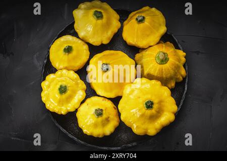 Autumn vegetables and mushrooms on a black background and a canvas napkin. Yellow squash, carrots, tomatoes and cucumbers, garlic, onions and zucchini Stock Photo