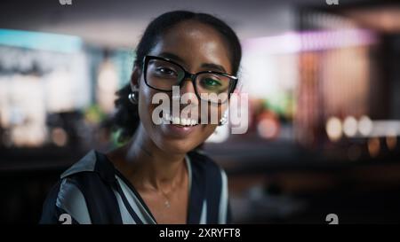 Portrait of Successful Black Businesswoman Using Desktop Computer, Analysing Data, Thinking and Solving Problems. Female Manager Looking At Camera And Smiling In Creative Agency Modern Office Stock Photo