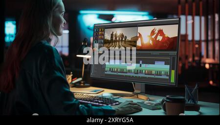Portrait of Female Videographer Working on a Film on Her Desktop Computer. Focused Woman Making a Video Montage and Design for a Clip in Creative Office at Night Stock Photo