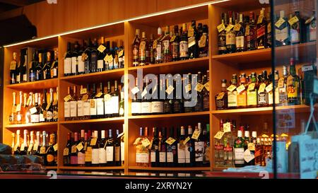 Bucharest, Romania - May 24, 2024: Wines and spirits alcoholic drinks bottles on shelves in small specialty shop Stock Photo