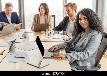Businesswoman Working on Laptop During Meeting in Modern Office Stock Photo