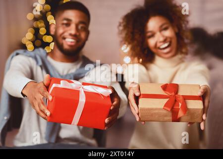 Excited afro couple holding xmas gift boxes and smiling Stock Photo