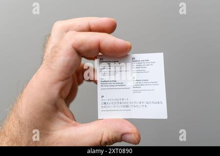 Paris, France - May 21, 2024: Feedback and help instruction paper for an IKEA product, featuring multiple languages including Spanish, German, Dutch, Italian, and Japanese, providing multilingual user support Stock Photo