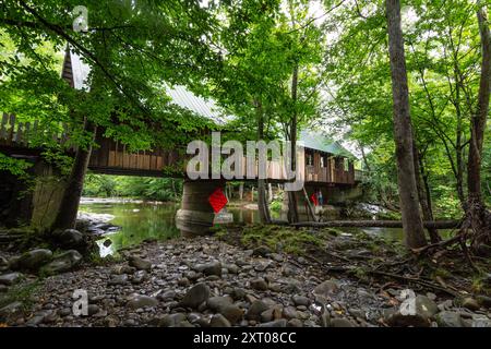 Pittman Center, Tennessee, USA-July 20, 2024: View of Emerts Cove Covered Bridge from the Little Pigeon River bank. Stock Photo